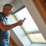 Homme en polo utilisant une télécommande Velux Integra