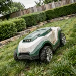 Robot tondeuse autonome sur une forte pente dans un jardin résidentiel avec haies et murs en pierre